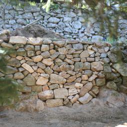 reparation de mur en pierre seche avec la pierre locale